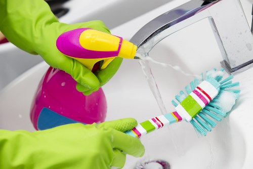 Cleaner applying safe procedures with protective gloves and mask
